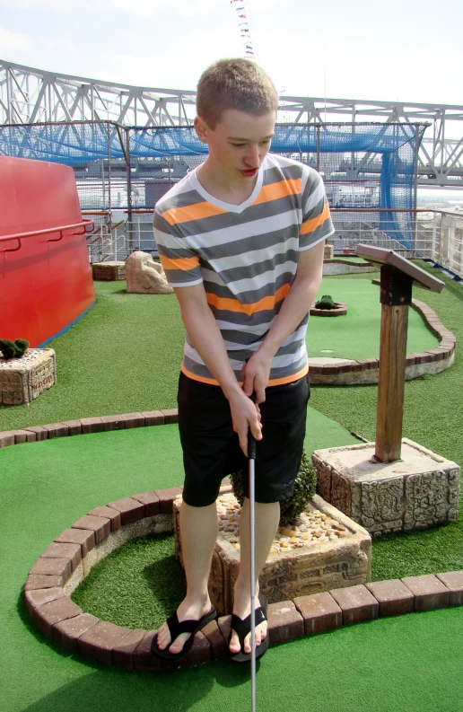 a boy holds an oar at the golf course