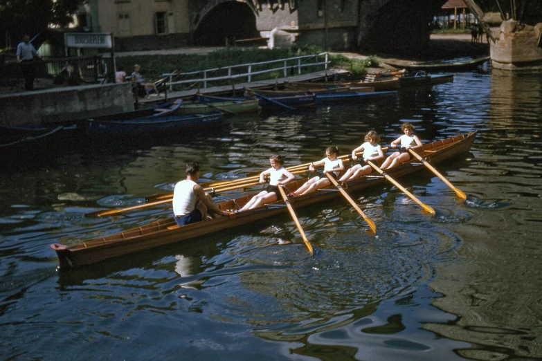 some people that are rowing a long boat