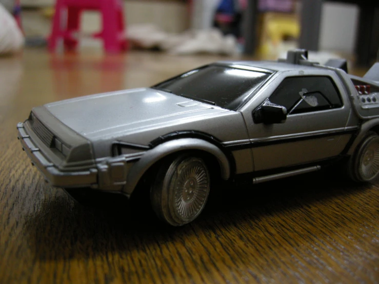 a toy car is sitting on a wooden table