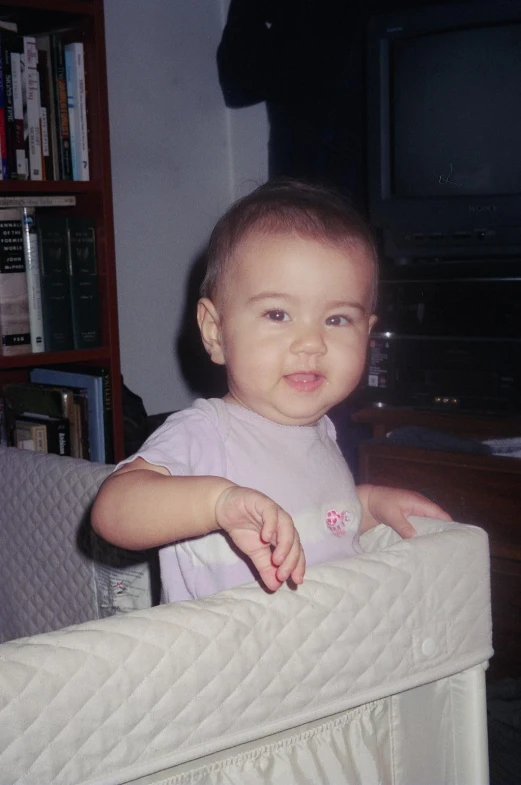 a little baby smiles while looking up at the camera