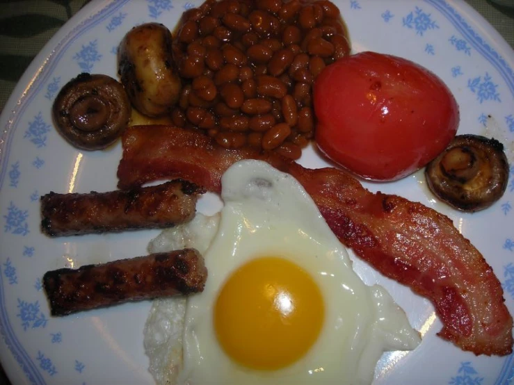the plate is filled with eggs, bacon, and mushrooms