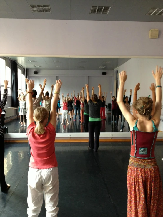 people standing in front of a large mirror at a dance studio