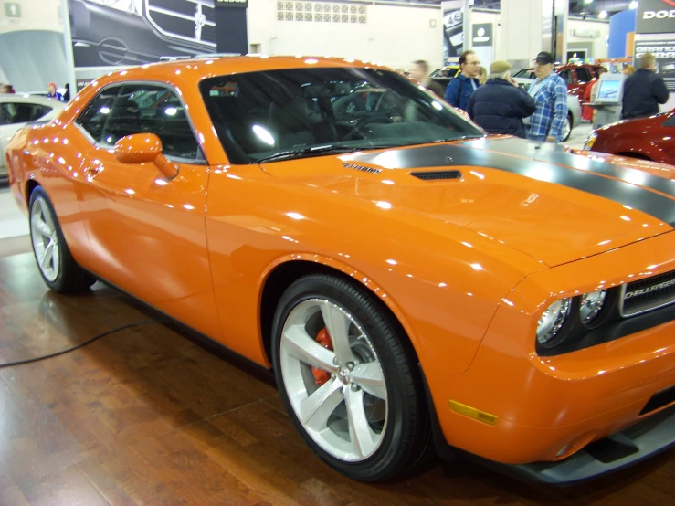 an orange sport car on display at a auto show