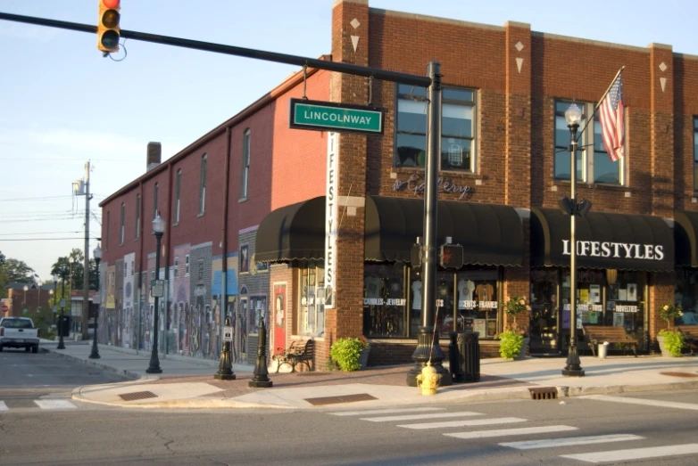 an intersection showing a brick storefront and a traffic light