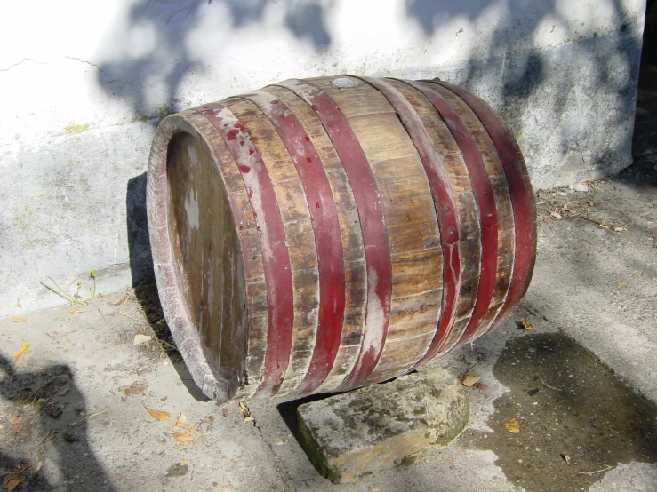 the wooden barrel is next to the cement