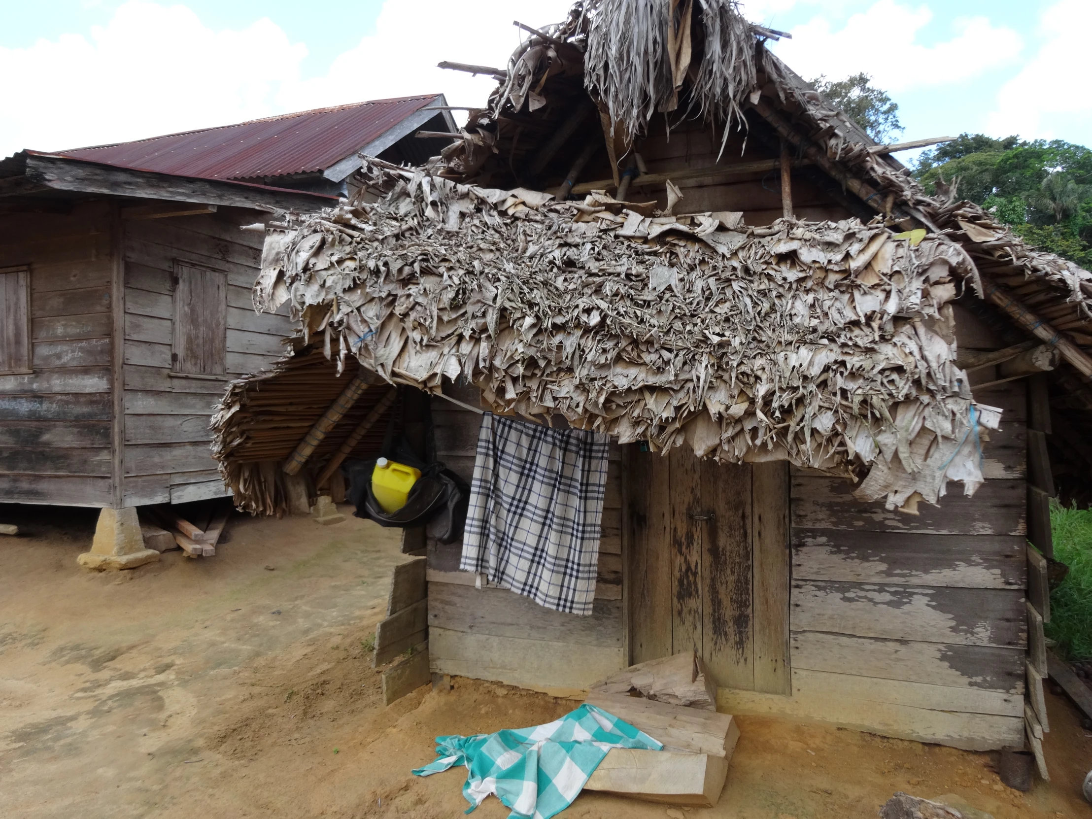 small mud house with a drying rack with clothes hung up