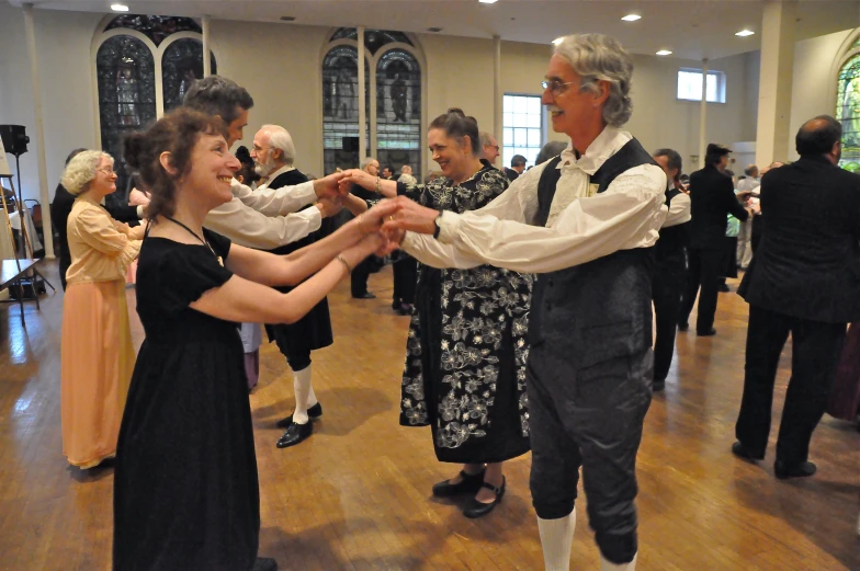 a group of people in fancy dress dance together