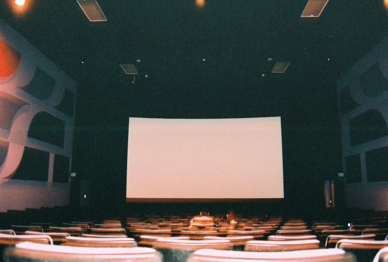 an empty auditorium with rows of chairs and projection screen