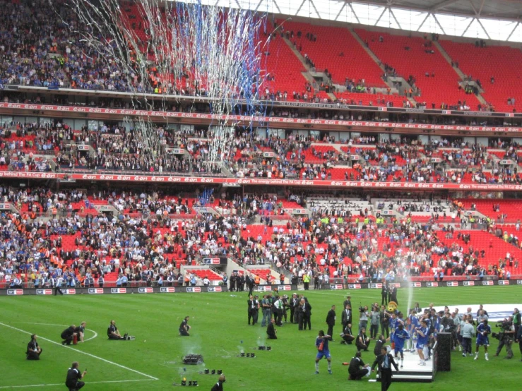 the crowd at an empty stadium gathers around the players