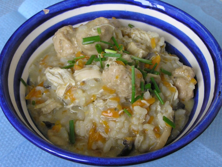 a blue and white bowl full of a tasty looking dish