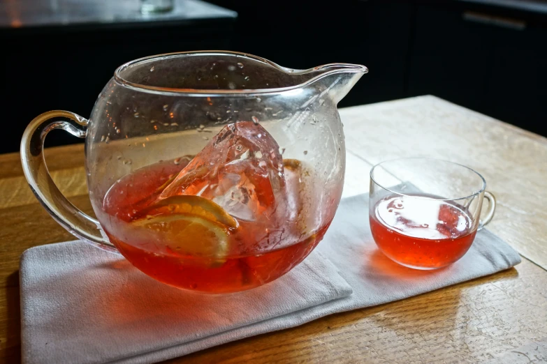 a pitcher of water with lemon slices and a glass