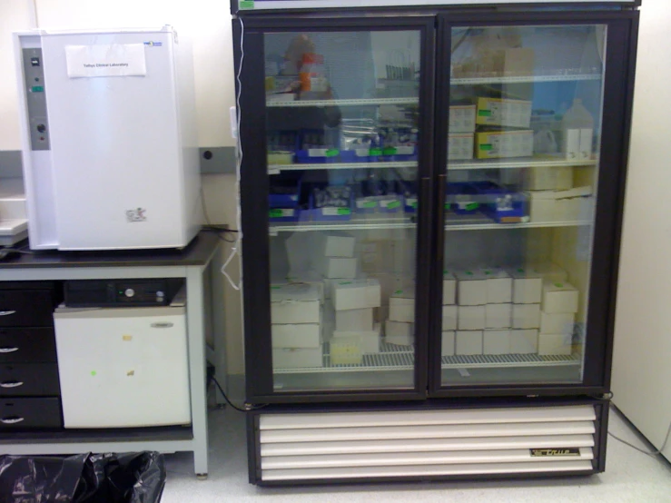 a small freezer sitting next to an ice chest in the corner