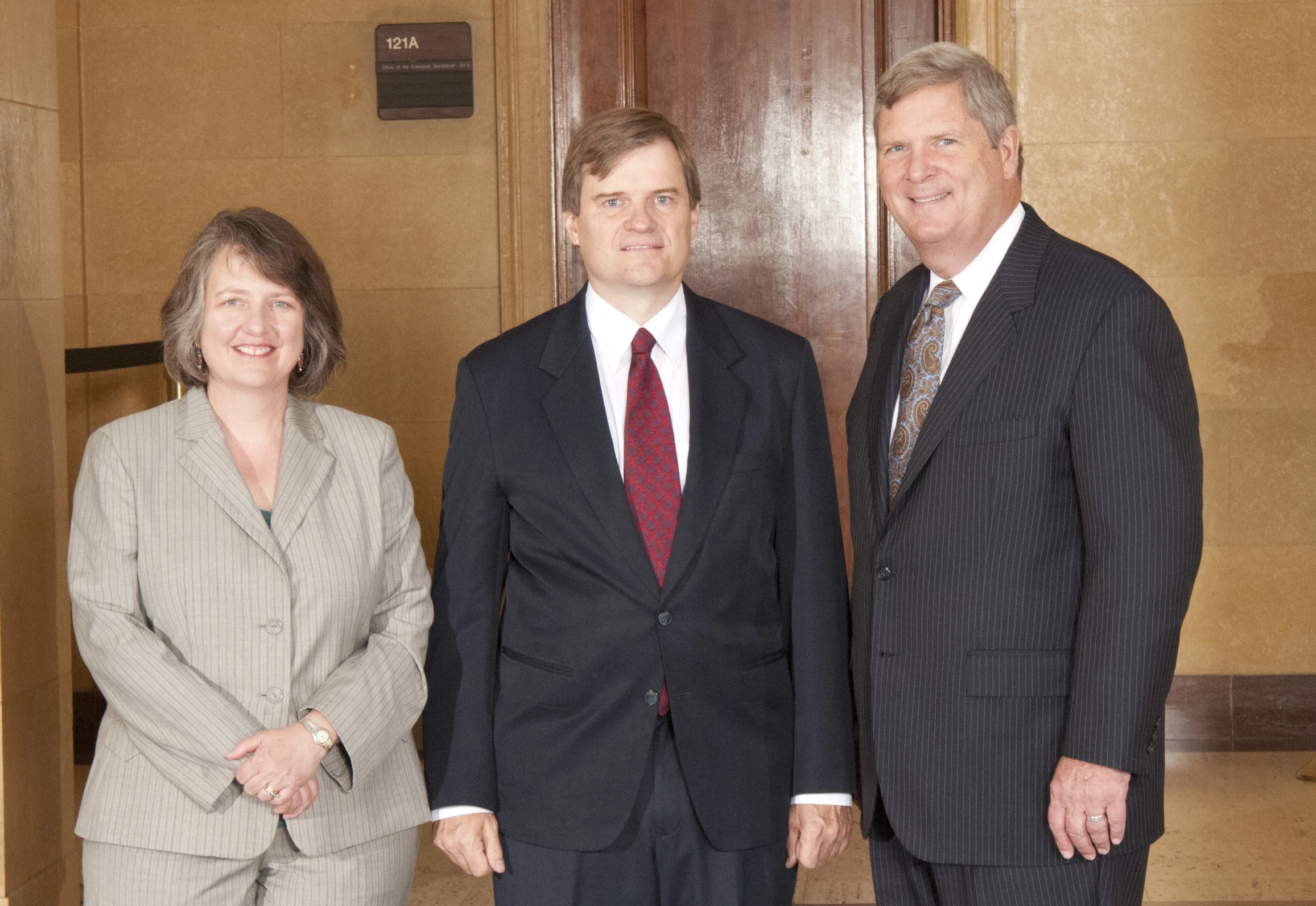 two men and a woman posing for the camera