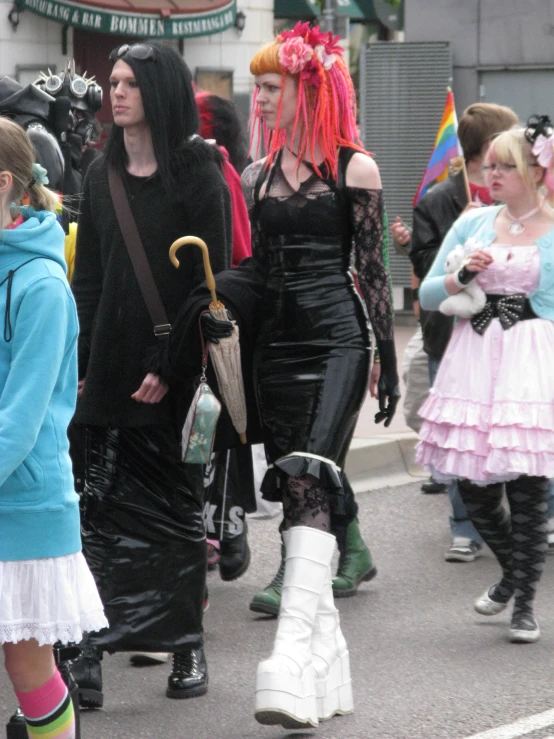 women dressed in goth clothing walk down the street