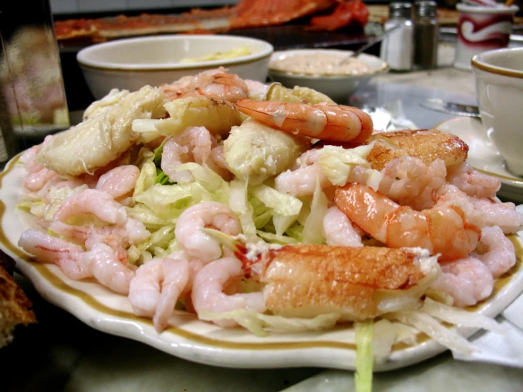 plate of lobster and greens sitting on a table