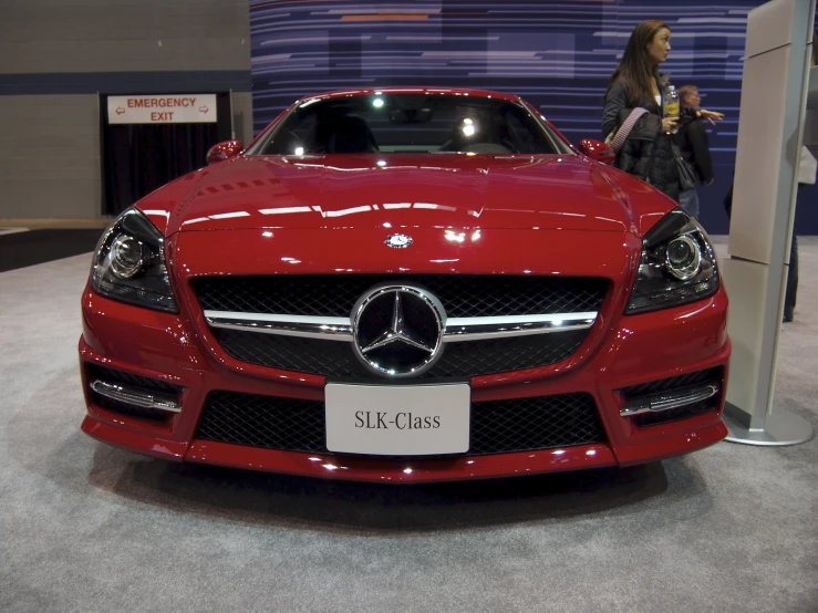 a beautiful red mercedes car on display at an automobile show
