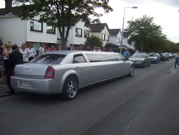 there is a silver rolls royce limousine that has a long tail