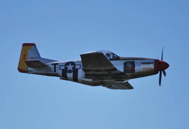 an old plane flies through the clear blue sky