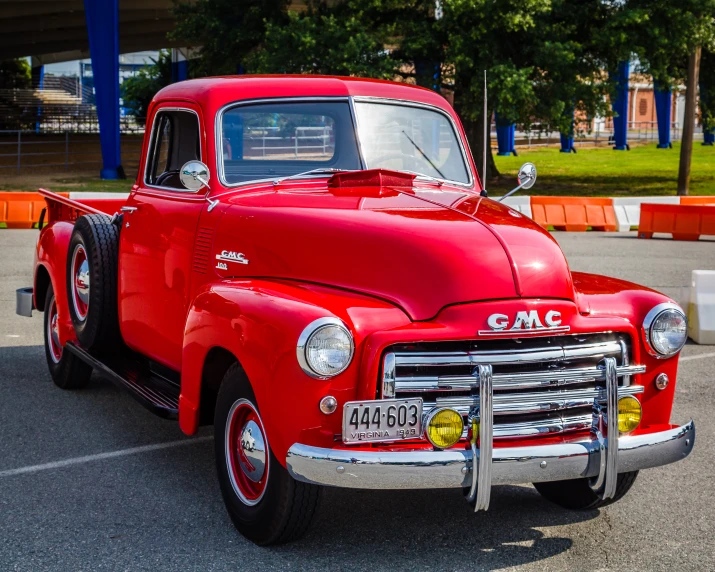 the classic red truck is parked in the parking lot