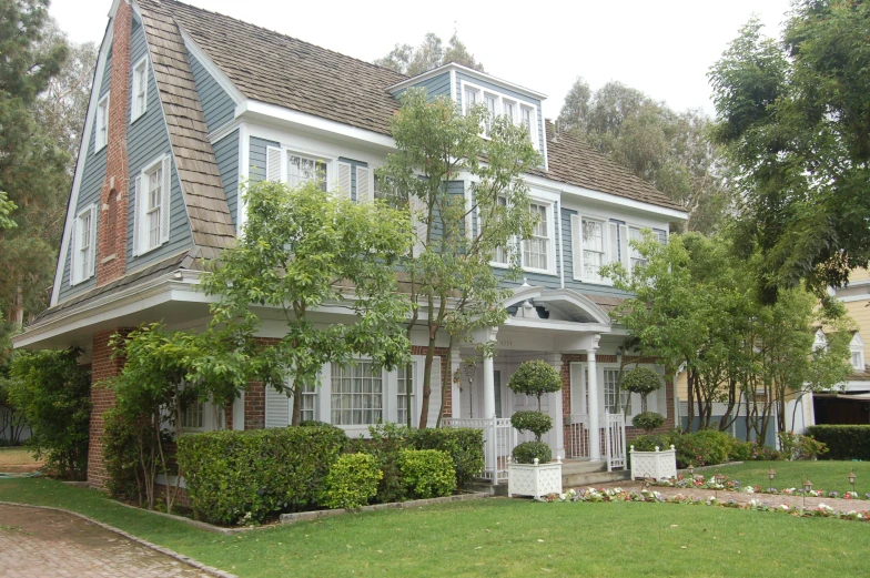 the front entrance and side of a two story house