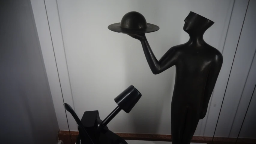 a statue with hat and a bag in it's hands