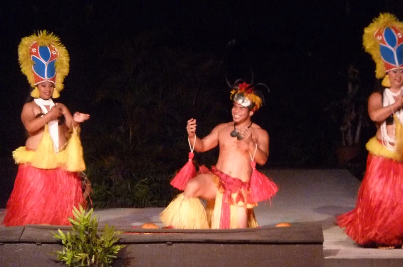 three dancers with red and yellow outfits performing