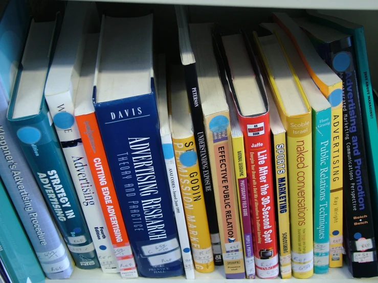 a bookshelf with many book in different colors