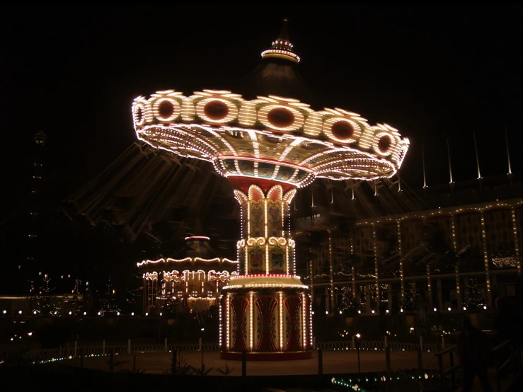 the fair rides are decorated in multicolored lights