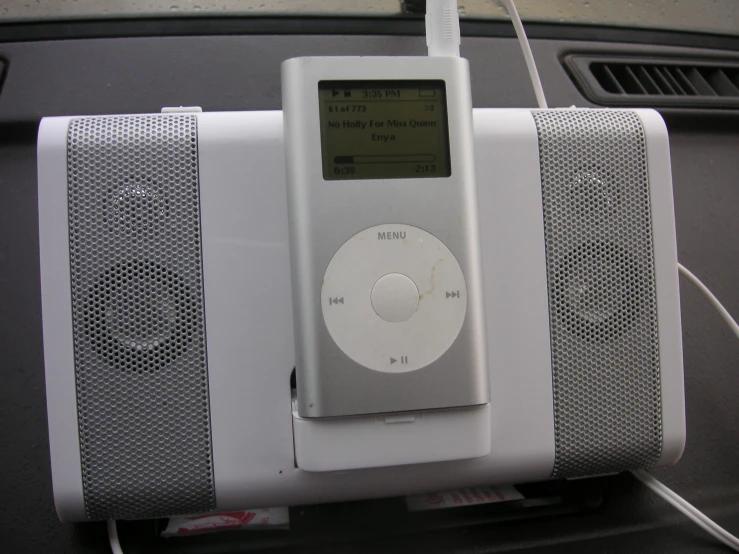 an apple ipod sitting on top of a white speaker system