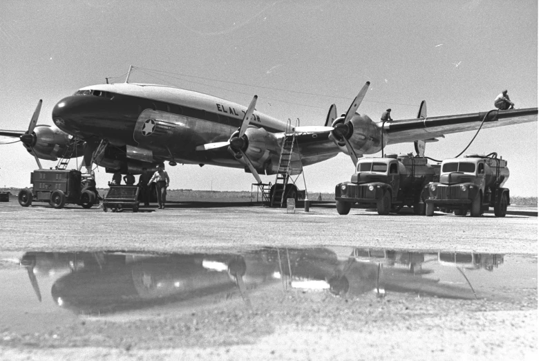 an airplane is parked on the ground next to some trucks