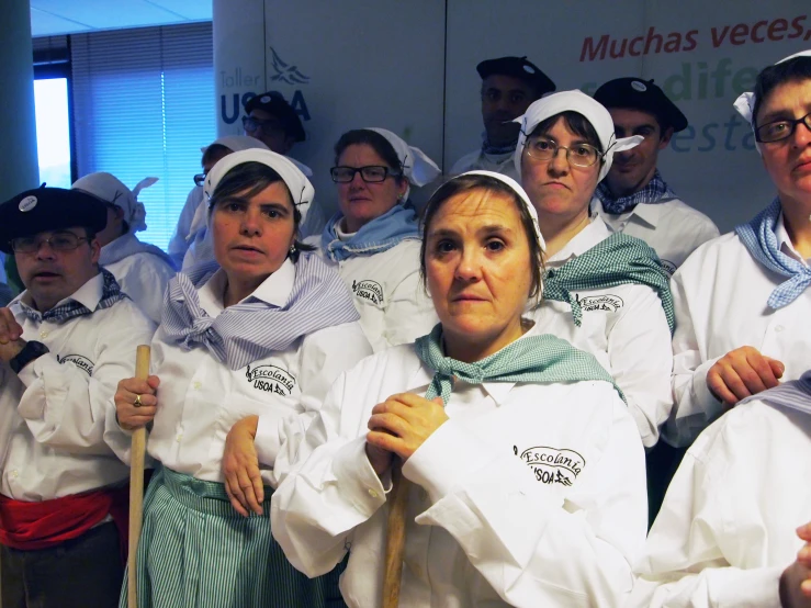 a group of people in chef uniforms holding wooden poles