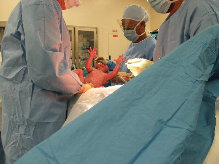  room with three doctors and a patient in scrubs