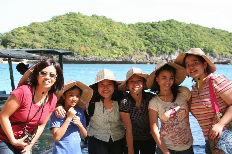 a group of women standing on a dock smiling