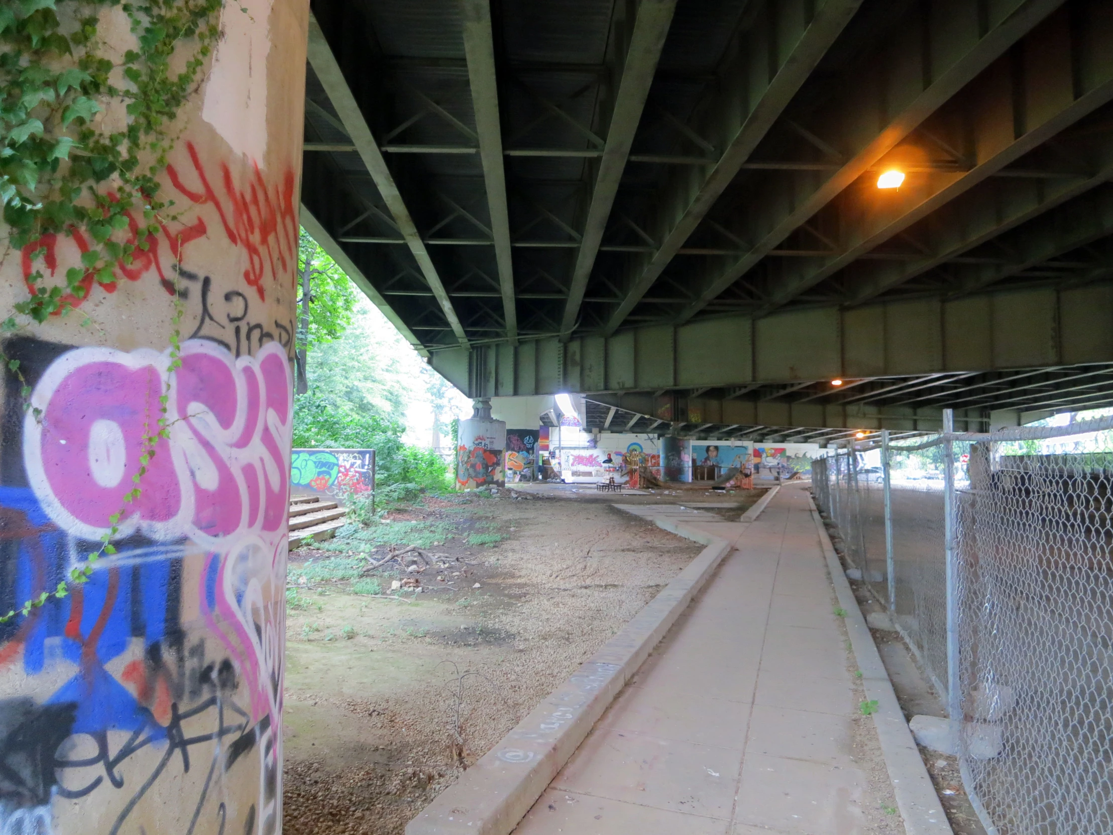 an abandoned building with graffiti on it next to a chain link fence