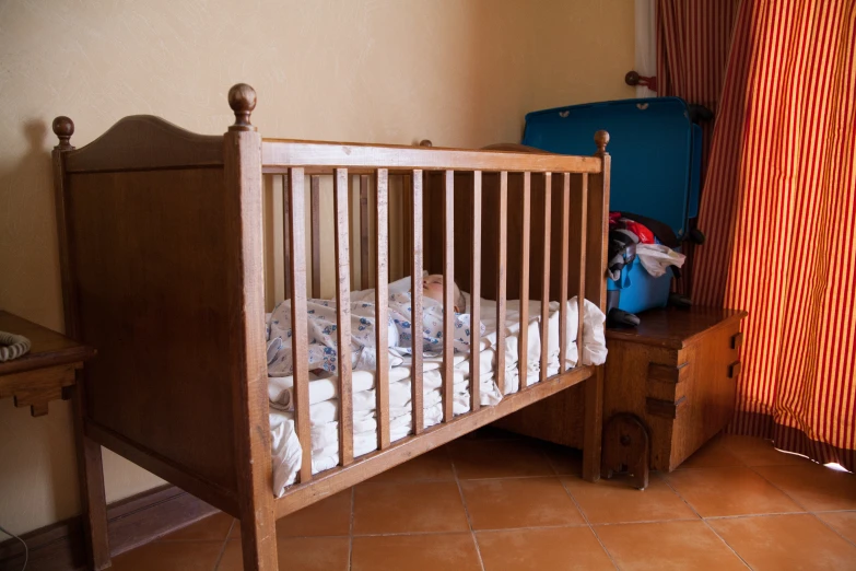 a baby crib next to a window with curtains