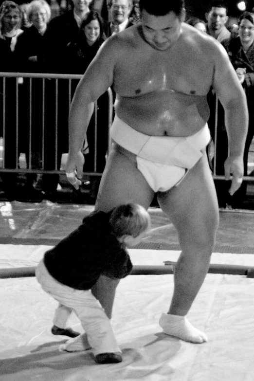 a wrestler standing over an injured little boy