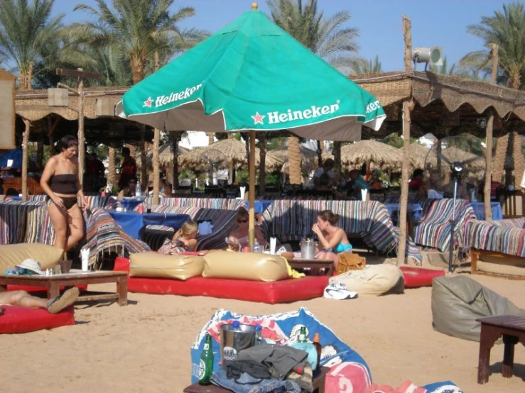 a couple laying on top of the beach with umbrellas