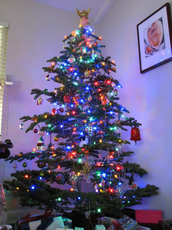 a brightly colored christmas tree sits in a corner