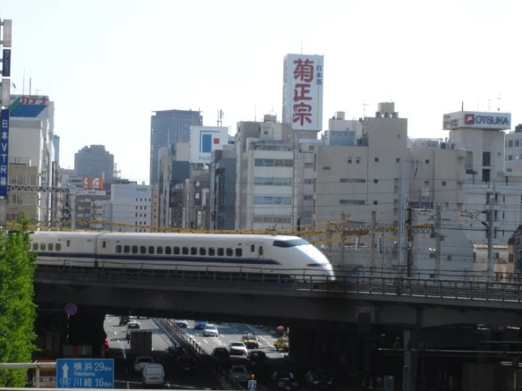 a train is riding on the bridge between some buildings