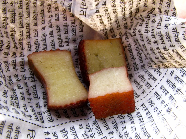 two slices of bread cut in to pieces sitting on newspaper