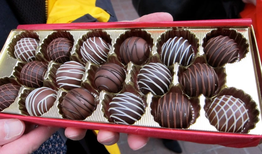 a box of chocolates with hand holding one