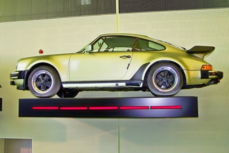 an old yellow porsche 9112 sits on display