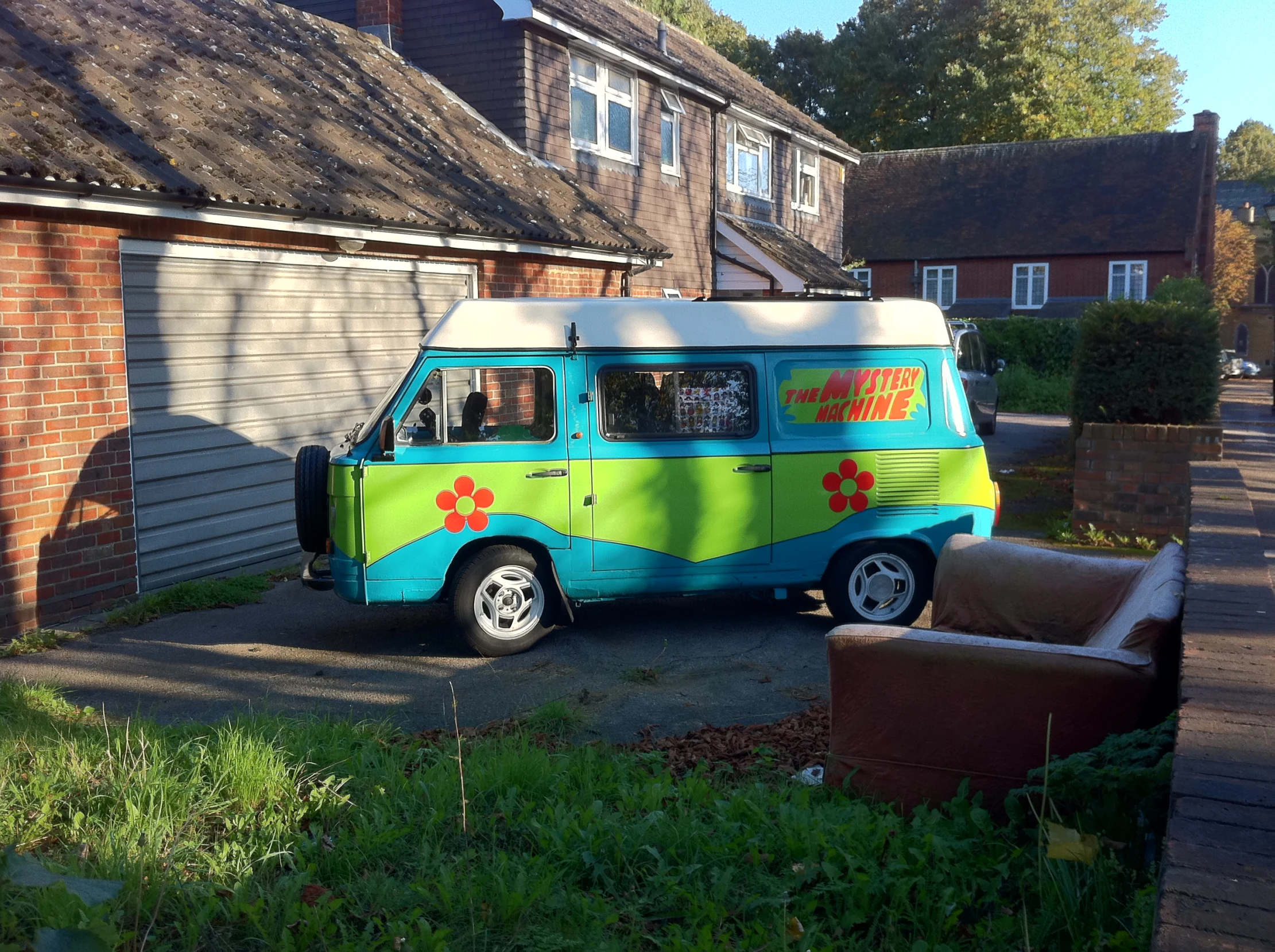 a blue, green and yellow van parked near houses