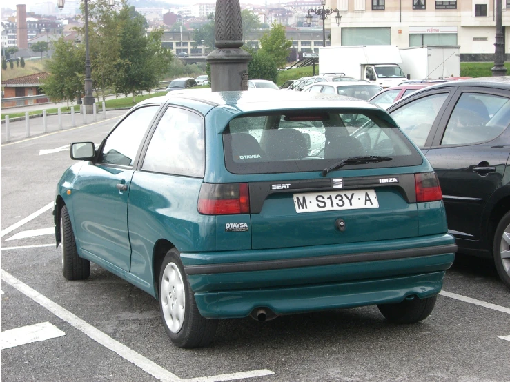 a picture of a small blue car in a parking space