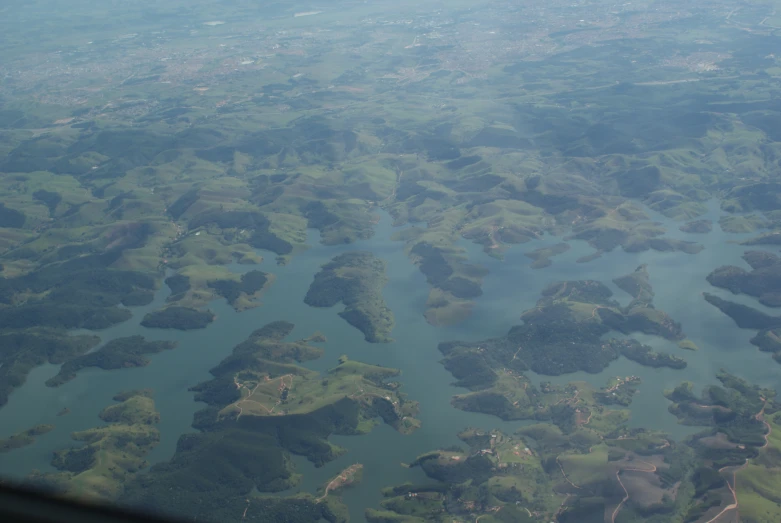 the view out an airplane window shows large green islands in the water