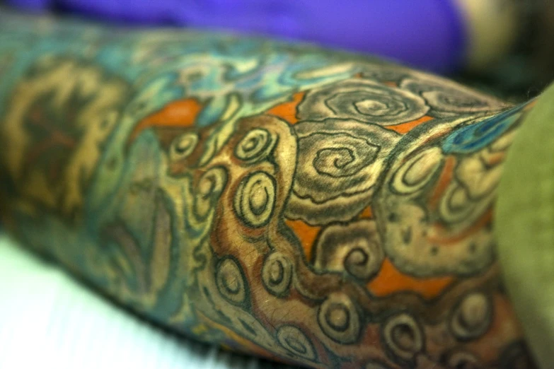 a close up view of the legs and legs of a man with a colorful tattoo on