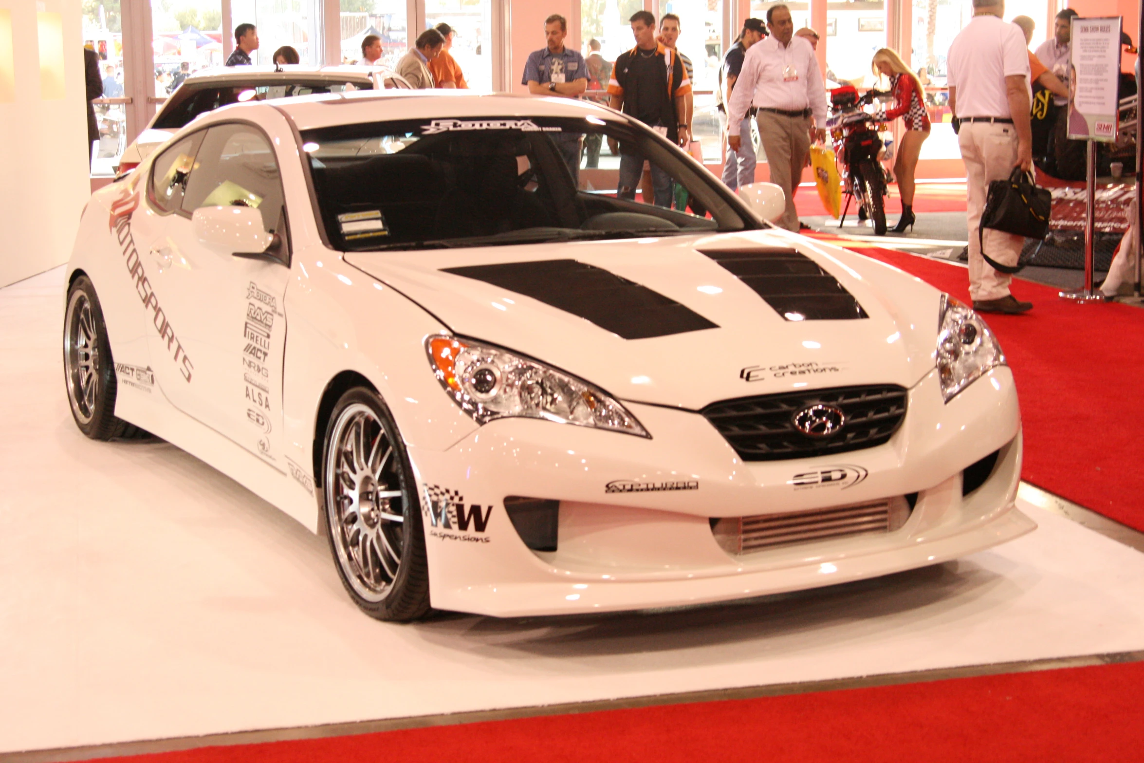 a white and black car sitting on top of a red carpet