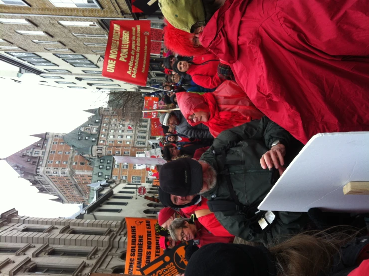 a large crowd of people holding signs on a city street