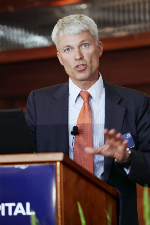 a man standing at a podium talking to the crowd