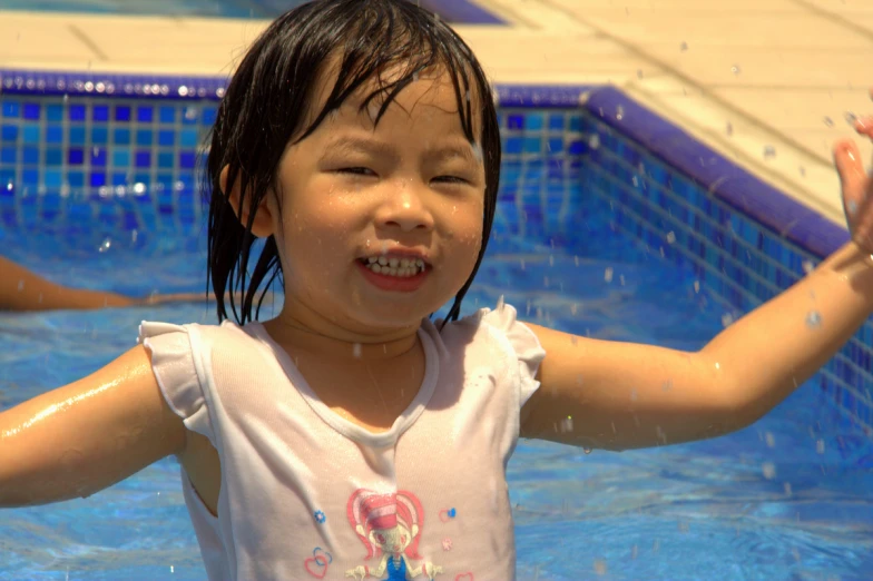 a  holds up her arms in the water